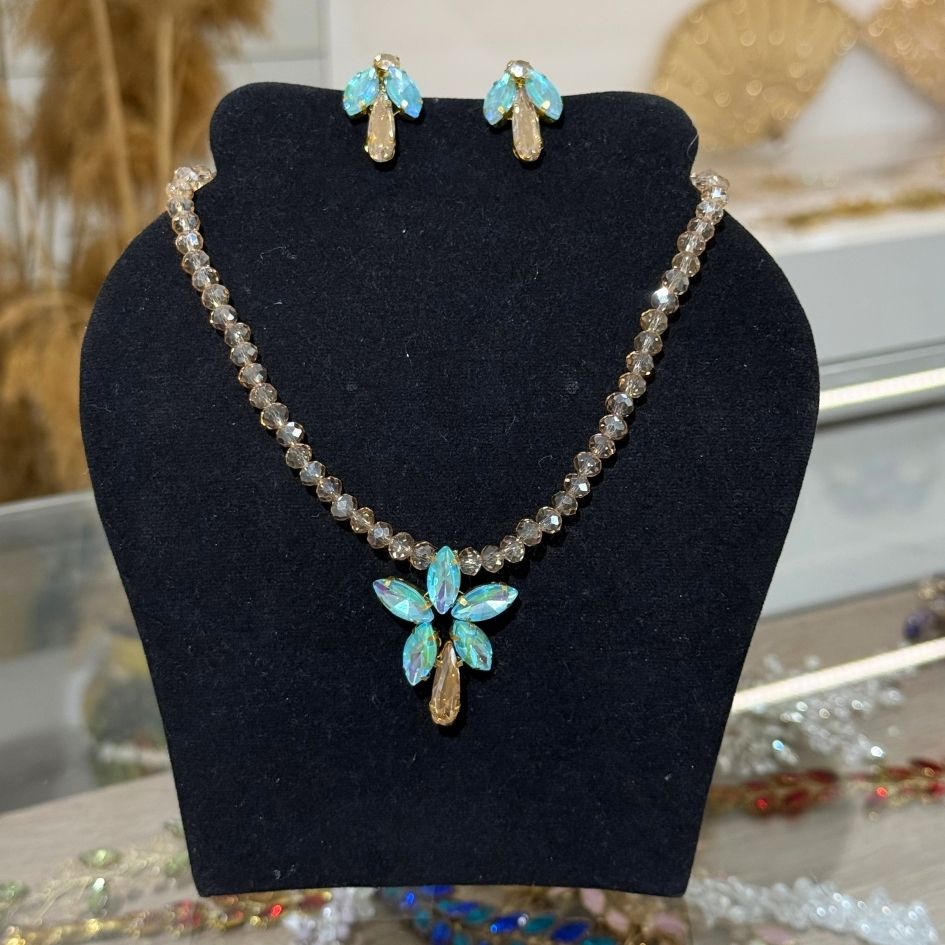 Parure collier et boucles d’oreilles dorée avec cristaux irisés bleu lagon