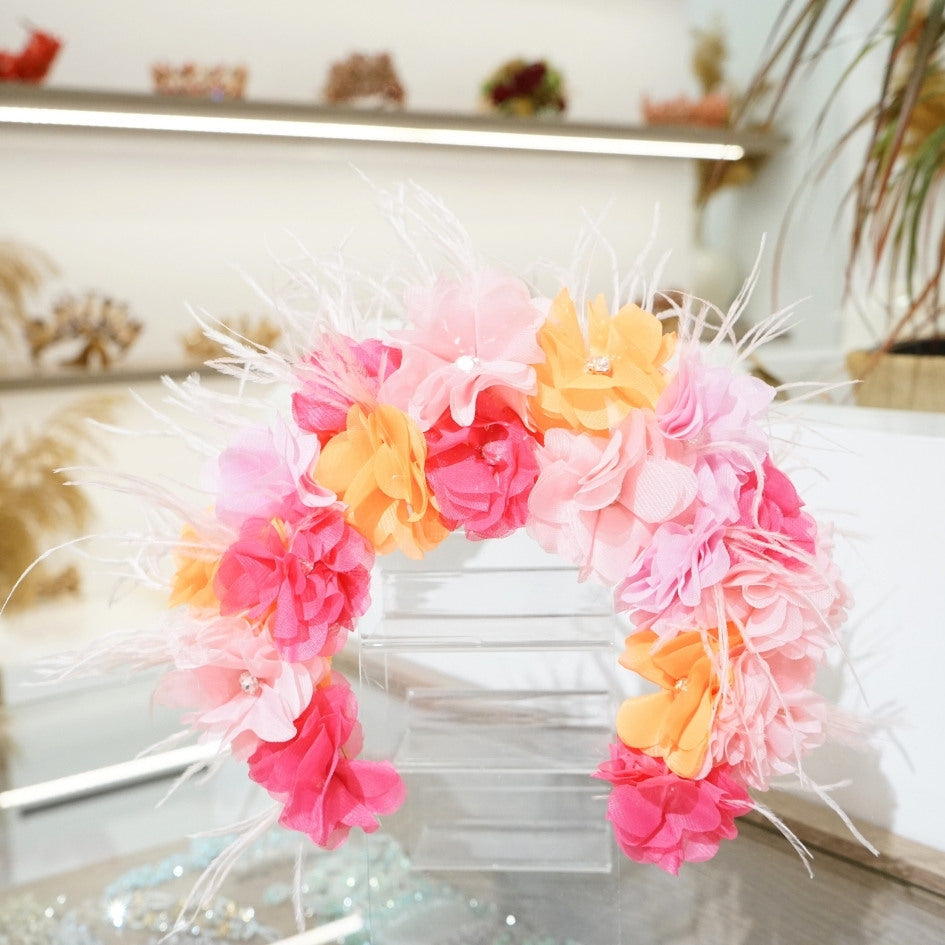 Bandeau floral en tissu avec détails roses, oranges et plumes